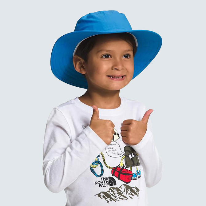 The North Face Kids' Horizon Brimmer Hat, a bright blue wide-brim sun hat worn by a smiling young boy giving a thumbs-up.