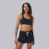 Vuori Women's Dynamic Bra, black sports bra worn by a smiling woman with wavy hair, styled for activewear comfort and support.
