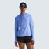 The North Face Women's Sunriser Hoodie, blue lightweight athletic hoodie with long sleeves and a high collar, paired with black shorts and a black cap.