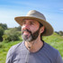 Sunday Afternoons Women's Cruiser Hat, wide-brim beach hat with chin strap worn outdoors on a sunny day.
