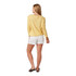 Carve Designs Women's Maui Short - 4" Inseam, back view of a woman wearing yellow floral top and white shorts, standing with one hand relaxed at her side, against a plain white background.