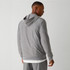 Fabletics The Cloud Jersey Hoodie, a man wearing a light gray hoodie with a subtle textured pattern, showing the back view.