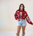 Gameday Social Women's Alabama Patched Up Crop Tee, model wearing a crimson cropped Alabama tee with collegiate patches and graphics, styled with denim shorts and cowboy boots.