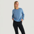 Free Fly Apparel Women's Bamboo Lightweight Fleece Crew, woman wearing a light blue fleece sweatshirt with long sleeves and a relaxed fit, standing against a plain white background.