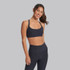 Vuori Women's Elevation Ruched Bra, stylish black sports bra with ruched detailing and adjustable straps worn by smiling woman