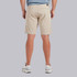 Vuori Men's Aim Short, a pair of beige men's casual shorts worn by a man standing against a light gray background.