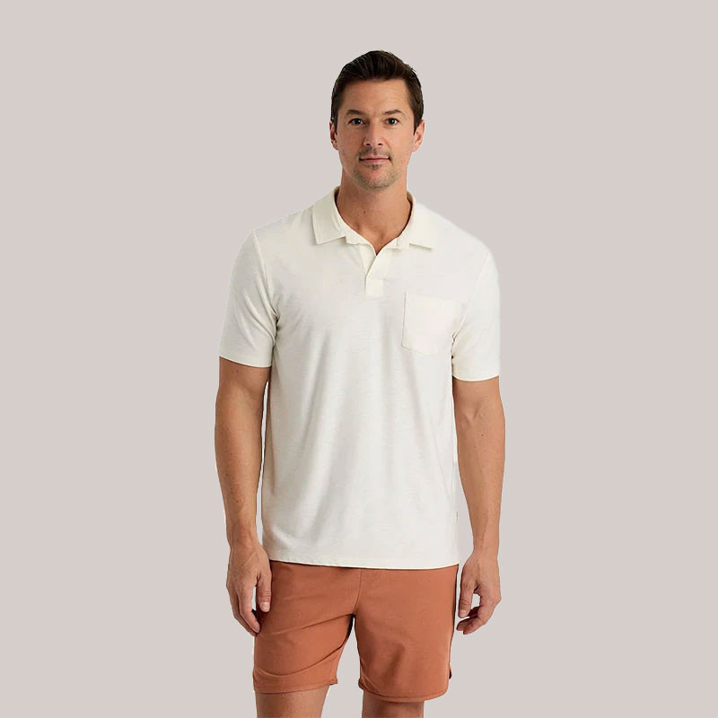 Free Fly Men's Bamboo Slub Polo II, man wearing white bamboo fabric polo shirt with a chest pocket, paired with tan shorts.