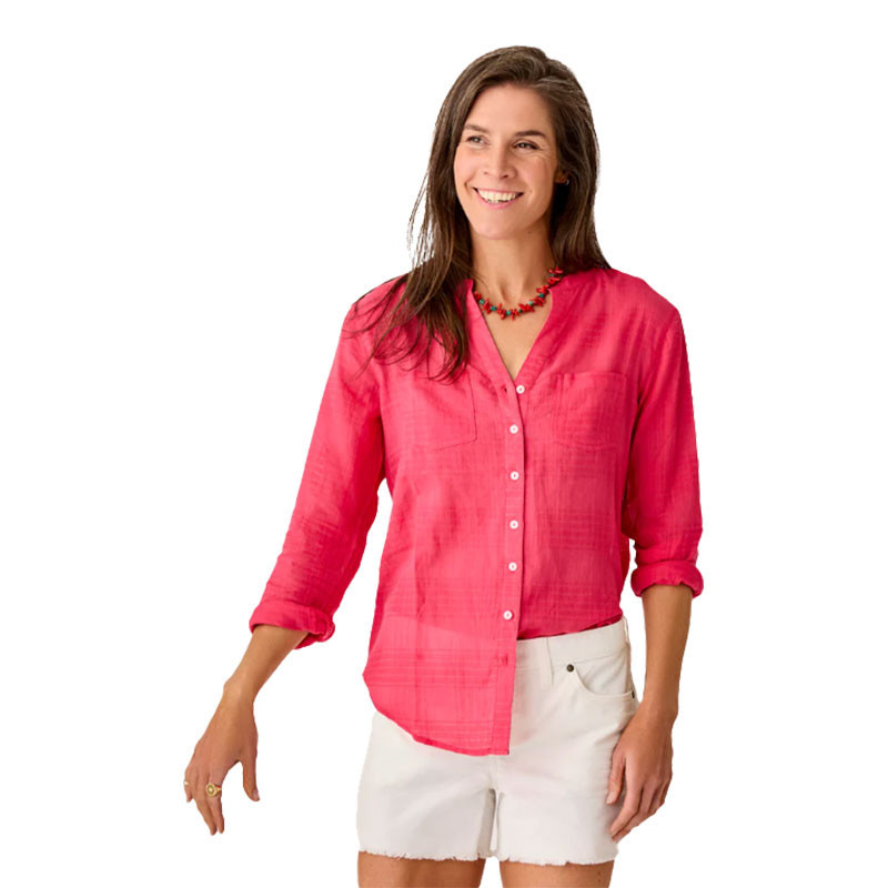 Carve Designs Carve Women's Dylan Textured Tunic, a woman wearing a vibrant pink textured tunic with a V-neck and button-down front, paired with white shorts and a colorful necklace.