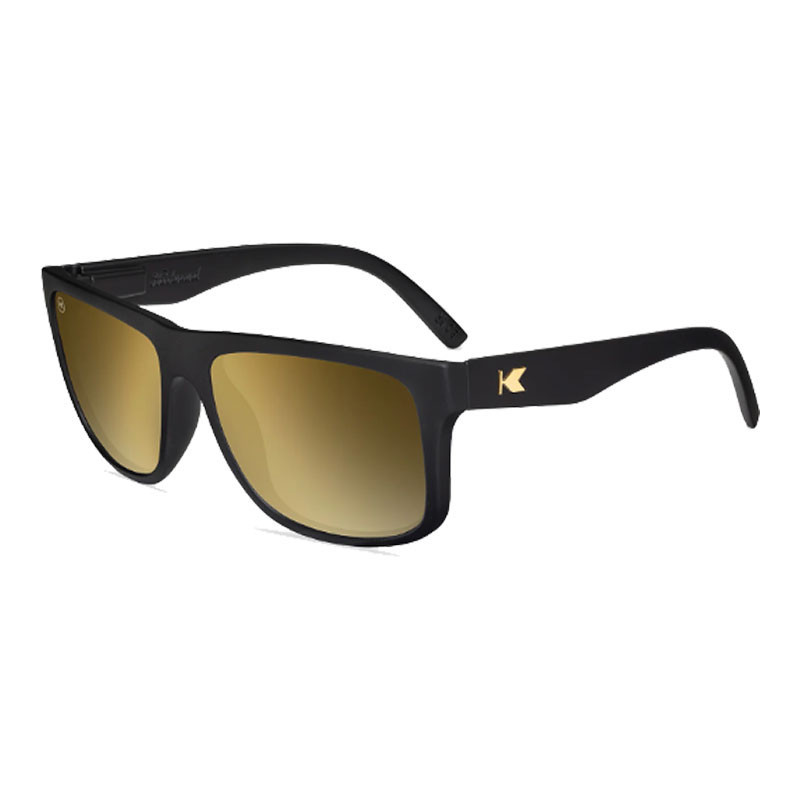 Knockaround Torrey Pines Sunglasses, black frame with gold-tinted lenses and a gold 'K' logo on the temple.