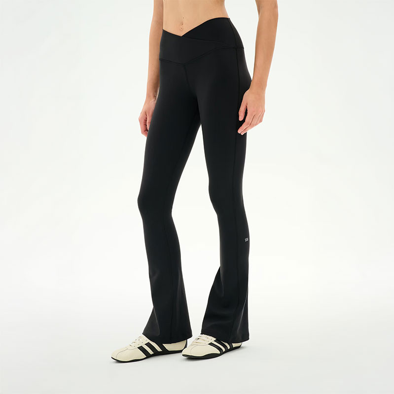 Splits59 Women's Raquel Crossover Supplex Flare 32 in, model wearing black high-waisted flare leggings with a crossover waistband and 32-inch inseam