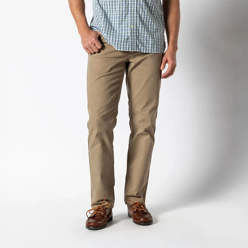 Duck Head Men's 1865 5-Pocket Field Canvas Pants - 30 Inch Inseam, khaki-colored casual men's pants with a straight fit and five-pocket design, styled with brown leather shoes and a plaid shirt.