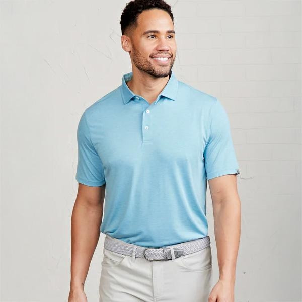 Tasc Performance Tasc Men's Cloud Polo, light blue men's performance polo shirt worn by a smiling man against a neutral background.