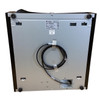Underside view of a silver metallic APG Vasario cash drawer chassis, showing four black rubber feet, structural mounting slots, a central manufacturer sticker, and a coiled black interface cable taped to the base.