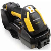 A high-angle, close-up studio shot on a clean white background showing a rugged, heavy-duty Datalogic PowerScan PM9600 industrial barcode scanner docked horizontally into its black wireless charging base station. The scanner features a distinctive high-visibility yellow and matte black rubberized casing designed for factory environments. The wide, angular crown of the scan head faces forward, displaying a white "DATALOGIC PowerScan" logo printed on a textured, carbon-fiber-style center plate, topped by a small yellow and white multi-indicator display window. The robust black charging cradle completely encloses the scanner’s handle and base, resting flat with wide mounting tabs visible on its left side.