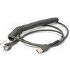 A heavy-duty, dark grey coiled interface cable for a Datalogic barcode scanner, displayed on a solid white background. One end features a standard USB Type-A connector, while the other end terminates in an RJ45 modular plug with a reinforced, flexible strain relief boot. The center section of the cable is tightly coiled in a spring-like fashion, transitioning into smooth, straight segments near the connectors.