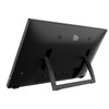 Rear three-quarter perspective view from the left side of the black Elo 2270L commercial touchscreen monitor (E511214). The monitor is propped up on a clean white surface by its integrated U-shaped kickstand, showcasing the angled profile and desktop setup. The matte black back panel displays the "ēlo" logo, dual speaker grilles, and the power button with a green LED indicator light on the lower left.