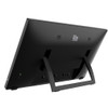 The rear panel of an Elo 21.5-inch widescreen touchscreen monitor (70L-Series / model E510259), captured from a low, rear three-quarter angle perspective facing right against a solid white background.

The image highlights the integrated, black u-shaped kickstand pulled outward from the matte black chassis, supporting the monitor in a reclined desktop configuration. The silver Elo logo, dual speaker grilles, and a glowing green power LED are visible on the back panel, showcasing the monitor's functional design when propped on a flat surface.