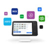 A black Square Stand for iPad (2nd generation) on a white base, displaying a retail point-of-sale interface on the screen. Floating around the stand are several colorful app icons, including Wix, GoDaddy, QuickBooks, Xero, Postmates, and others, against a clean white background.