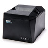 Three-quarter angled view looking down at the front and right side of a dark gray Star TSP100 thermal receipt printer against a white background. The front panel features the blue-accented logo and lower status lights, while a rectangular cover release lever with an arrow is visible on the angled top-right section of the housing.