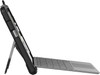 A side profile shot of the Microsoft Surface Go tablet enclosed in the black UAG rugged case. The device is propped up on a surface using its silver integrated kickstand, with a grey Microsoft Type Cover keyboard attached and laid out flat in front.