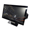 Front three-quarter view of an Elo I-Series 21.5" touchscreen POS terminal on a black desktop stand. A black magnetic stripe reader (MSR) is attached to the right side of the gloss-finish bezel, which shows a reflection of industrial warehouse shelving.
