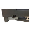 A close-up, horizontal view of the lower back edge of the gray plastic body. A modular RJ11 jack for a cash drawer connection is inset within a gray metal bracket labeled "21". Part of a white plastic cable routing guide is visible on the right.