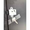 Close-up view of the lock housing mounted on the black metal till lid with a silver key taped beside it.