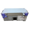 Rear angle view of a silver power supply unit showing the standard 3-prong AC power inlet port, specification label, and blue plastic mounting latches along the top edge.
