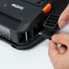 Close-up of a person plugging a USB cable into the protective side port cover of the Brother RuggedJet mobile printer.