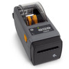 High-angle front view of the grey Zebra ZD411d direct thermal desktop printer showing the LED status interface, control buttons, and clear media window revealing internal yellow media guides.