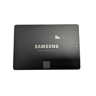 A top-down, full-frame studio shot of the front of a black Samsung 860 EVO 250GB 2.5-inch SATA III Internal Solid State Drive (SSD). The drive has a matte black finish with the "SAMSUNG" logo in bold, silver-white lettering in the center, and the words "Solid State Drive" printed in a smaller, thinner font directly below it. At the bottom center, there is a small, light gray square accent. On the right edge, a small white arrow points toward the SATA connection side. There is a small piece of white sticker residue or a minor scuff mark on the upper-right portion of the drive's face. The background is a solid, clean white.