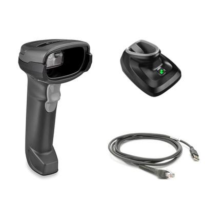 A product kit display isolated on a white background showing the components of a wireless barcode scanner system. On the left is a handheld 2D imager in twilight black with a light gray trigger and a recessed scan window. To the right is a matching black presentation charging cradle with a green LED power indicator illuminated. Below the cradle is a coiled dark gray shielded USB cable featuring a standard USB-A connector on one end and a modular RJ45-style connector on the other.