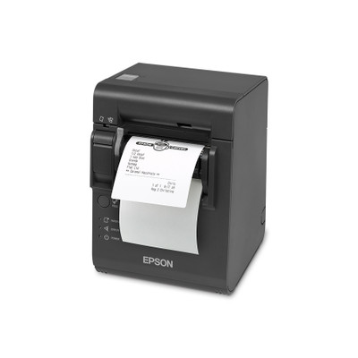 A high-angle, front-facing three-quarter view of a dark gray Epson TM-L90 Plus linerless thermal printer on a crisp white background. A white adhesive order ticket with a printed coffee shop logo and a drink order list feeds out from the front delivery slot. The printer features a prominent white Epson logo on the lower front, with a circular feed button and small labeled indicator lights for paper, error, and power aligned on the bottom left.