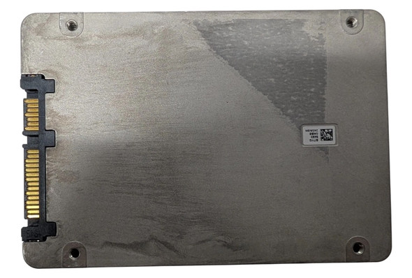 A top-down view of the underside of a 2.5-inch silver metal solid-state drive (SSD). On the left edge, the gold-plated SATA data and power connectors are visible within a black plastic housing. The metal casing shows a slightly brushed texture with four screw holes in the corners. A small white sticker with a QR code and alphanumeric text is located on the right side of the drive.