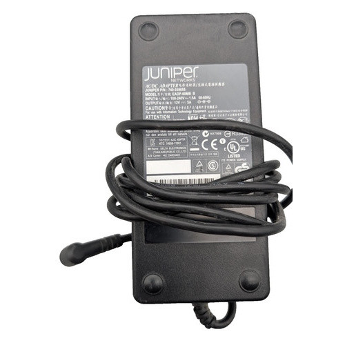 An overhead, eye-level shot of a rectangular, black Juniper Networks AC/DC power adapter. The adapter is oriented vertically, and its long, black power cord is wrapped multiple times around its center. A small portion of the cord extends to the bottom, and the connector end of the cord is visible to the left. The top of the adapter features a large, light-gray sticker with black text, including the Juniper Networks logo, model number, and technical specifications. The background is a plain white.