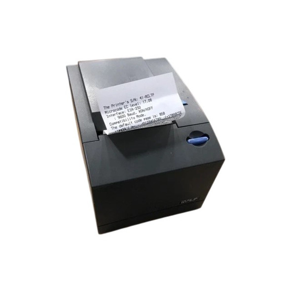 A three-quarter studio shot of a Toshiba 4610-1NR SureMark thermal receipt printer in Iron Grey, shown with a printed test receipt emerging from the exit slot. The printer features a matte dark charcoal finish and a compact, industrial design.

Key Visible Features:

Test Receipt: A white thermal receipt is partially dispensed from the top slot. The printed text includes technical details such as the serial number (S/N: 41-RCLTP), microcode level, and interface settings (EIA-232).

Control Elements: A blue circular latch or dial is located on the right side of the front panel. A small blue triangular feed button and status LEDs are partially visible on the top right deck.

Chassis Design: The unit has a two-part plastic construction with a clean horizontal seam. The top cover is a large, flat rectangular panel that opens for paper loading.

Branding: A small silver plate with model and serial information is located at the bottom right corner of the front face.

The unit is isolated against a clean white background, providing a clear view of the printer in an active state.