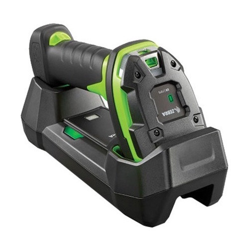 A three-quarter isometric view of a Zebra 3600 series ultra-rugged barcode scanner resting horizontally in its charging and communications cradle. The scanner features a high-visibility lime-green body encased in thick, black rubberized industrial armor.

The image highlights:

The scanner head seated securely in the front of the cradle, showing the "Zebra" logo and a green status LED on the top panel.

The ergonomic handle with a textured black grip extending toward the rear of the base.

The ruggedized cradle, constructed from heavy-duty black plastic, designed to hold the scanner stable in industrial environments.

The entire assembly is shown against a clean, solid white background.