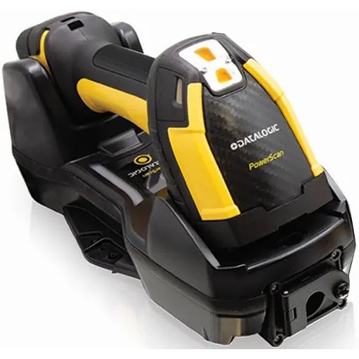 A high-angle, close-up studio shot on a clean white background showing a rugged, heavy-duty Datalogic PowerScan PM9600 industrial barcode scanner docked horizontally into its black wireless charging base station. The scanner features a distinctive high-visibility yellow and matte black rubberized casing designed for factory environments. The wide, angular crown of the scan head faces forward, displaying a white "DATALOGIC PowerScan" logo printed on a textured, carbon-fiber-style center plate, topped by a small yellow and white multi-indicator display window. The robust black charging cradle completely encloses the scanner’s handle and base, resting flat with wide mounting tabs visible on its left side.