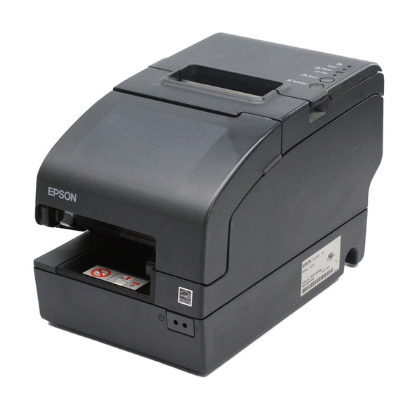 A three-quarter perspective view of an empty dark gray Epson TM-H2000 multifunction POS printer sitting on a white background. The image showcases the unit's elongated footprint, featuring a recessed thermal paper exit slot on top and an open, horizontal check-feeding slot on the lower front panel containing a white instructional label with red icons. A white manufacturer's product and serial number label is visible on the lower right side chassis.