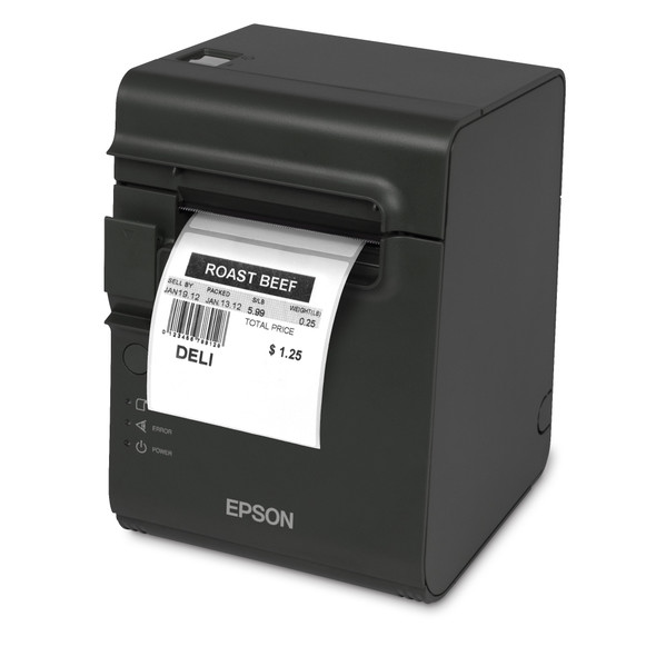 Three-quarter studio shot of a dark gray Epson TM-L90 Plus LFC thermal desktop POS printer against a pure white background. The compact, vertical-profile printer is shown dispensing a freshly printed white direct thermal deli label. The label reads "ROAST BEEF" in bold block letters, followed by itemized pricing details, a barcode, and the word "DELI". The front panel features a prominent silver Epson logo at the bottom, alongside vertical LED indicator lights for status, error, and power on the lower left edge.