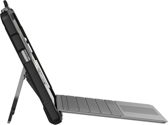 A side profile shot of the Microsoft Surface Go tablet enclosed in the black UAG rugged case. The device is propped up on a surface using its silver integrated kickstand, with a grey Microsoft Type Cover keyboard attached and laid out flat in front.