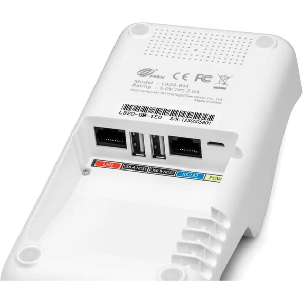 A close-up view of the underside of a white PAX L920-BM base station. The image clearly details the recessed connectivity hub, showcasing ports labeled with color-coded stickers: a red "LAN" port, two black "USB A-HOST" and "USB B-HOST" ports, a blue "RS232" port, and a yellow "POWER" micro-USB port. The product sticker shows regulatory logos, the model name "L920-BM", and the specific part number "L920-BM-1EO".