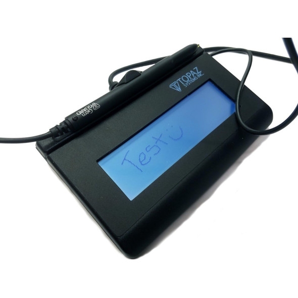 Angled view of a black Topaz SigLite LCD electronic signature capture pad with a blue backlit display showing written test text, attached cord, and stylus in its pen holder.