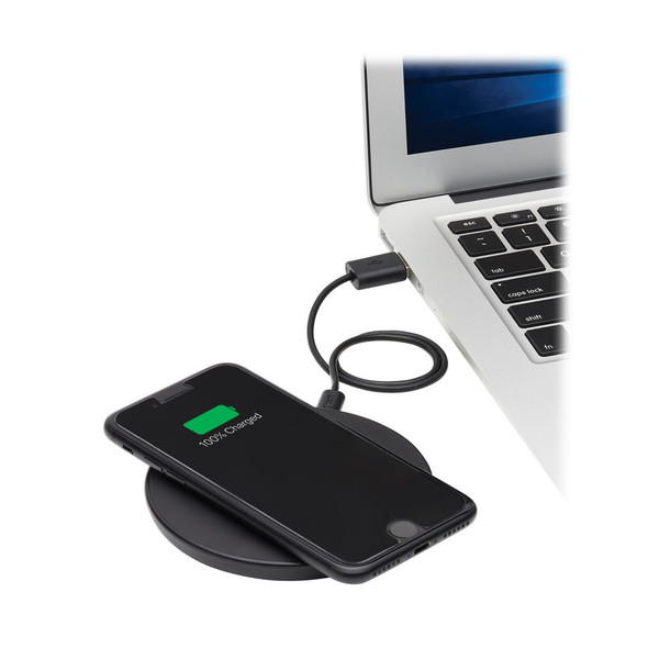 An Eaton Tripp Lite Series 10W wireless charging pad connected via USB to a laptop, with a smartphone resting on top displaying a 100% charged battery status.