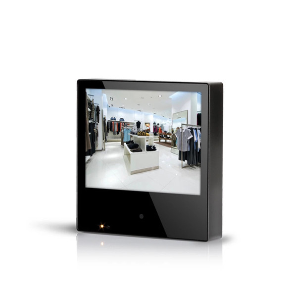 Front view of the Clinton Electronics 8-inch Public View Monitor showing its compact black housing, 8-inch display panel showing a retail store interior feed, and an indicator light on the lower bezel.