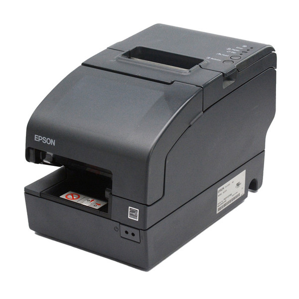 A three-quarter perspective view of an empty dark gray Epson TM-H2000 multifunction POS printer sitting on a white background. The image showcases the unit's elongated footprint, featuring a recessed thermal paper exit slot on top and an open, horizontal check-feeding slot on the lower front panel containing a white instructional label with red icons. A white manufacturer's product and serial number label is visible on the lower right side chassis.