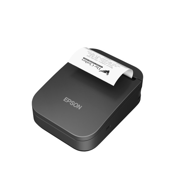 An isometric, high-angle studio shot of the black Epson Mobilink TM-P80II mobile wireless receipt printer (MPN: C31CK00001) printing an active receipt, angled to show the top face and right profile against a pure white background. A white thermal paper receipt feeds outward from the top slot, showcasing a sample transaction print layout with "The Clothes" company logo. The silver EPSON brand name is cleanly centered on the lower main panel, and the small oval USB-C charging port is visible on the lower right-hand casing.