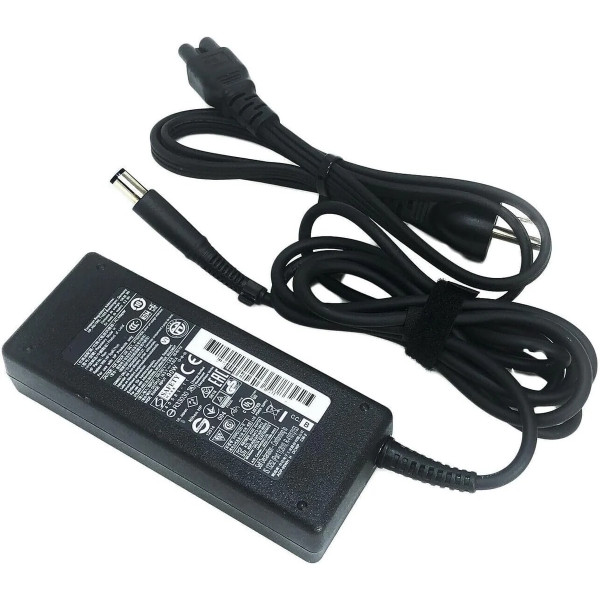 An HP laptop charger kit isolated on a clean white background. The image features a large, rectangular black AC power adapter brick with a prominent white specification label showing a barcode and numerous regulatory safety symbols. An attached black DC power cable extends from the lower right of the brick, looped and bound tightly with a black fabric hook-and-loop strap, terminating in a straight, large cylindrical barrel connector tip with a hollow center. Positioned above the brick is a separate, neatly bundled black AC wall power cord with a 3-prong plug on one end and a cloverleaf connector on the other.