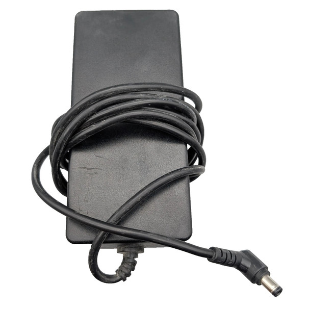 An overhead, eye-level shot shows the back of a rectangular, black Juniper Networks AC/DC power adapter. The adapter is oriented vertically, and its long, black power cord is wrapped multiple times around its center. A portion of the cord extends from the bottom of the adapter and ends in a right-angled barrel connector in the bottom right corner of the frame. The background is a plain white.