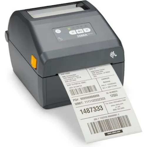 A front perspective view of a Zebra ZD421c thermal desktop label printer in a dark charcoal gray finish. The device is shown printing a large shipping label that features multiple barcodes, addresses, and tracking numbers.

The printer has a rounded, compact design with a prominent top-loading compartment featuring a clear window to view the media roll. On the top face, there is a silver interface panel with five LED status icons and three physical buttons: Pause, Feed, and Cancel. A yellow release latch is visible on the side, and the white Zebra logo is printed on the lower right front corner.